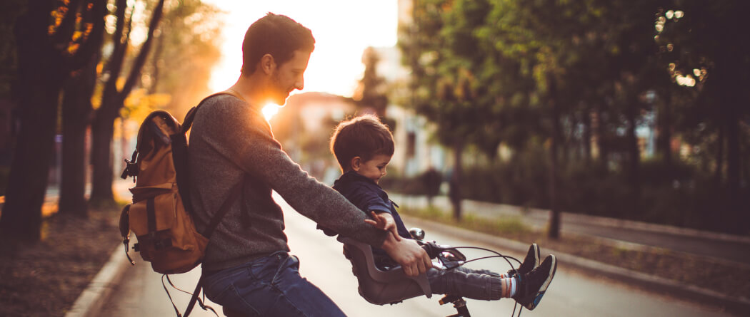 A dad and kid on a bicycle
